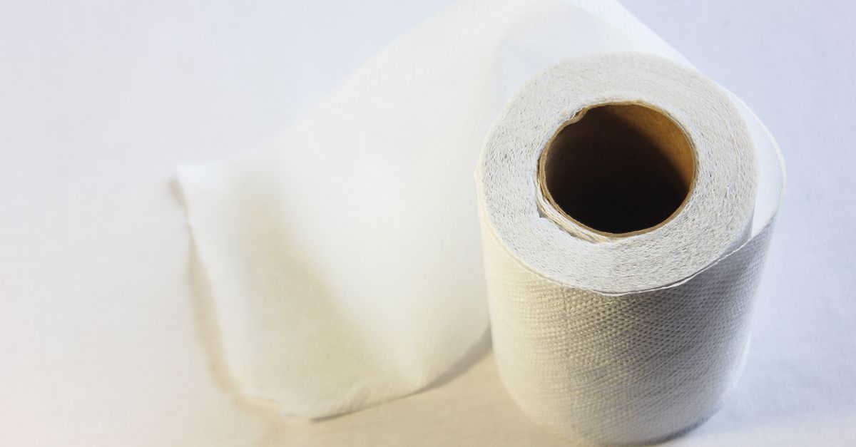Rollo de paño absorbente industrial extendido sobre el piso de una fábrica junto a una fuga de aceite